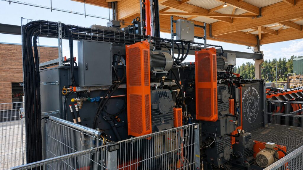 Écorceuse Valon Kone et ses motorisations orange, sous une charpente en lamellé-collé